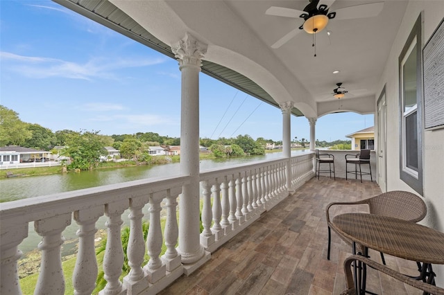 balcony with a water view and ceiling fan