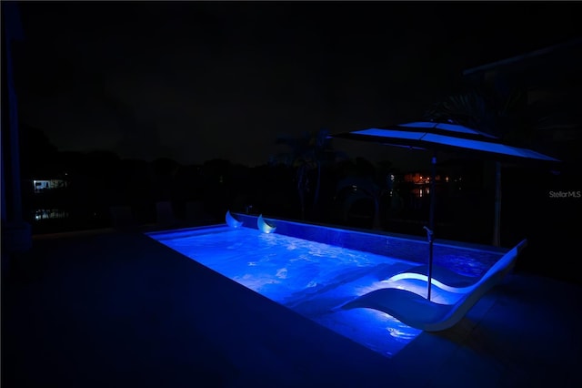 view of pool at twilight