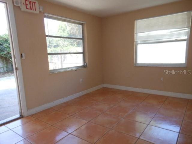 empty room featuring light tile patterned floors and baseboards