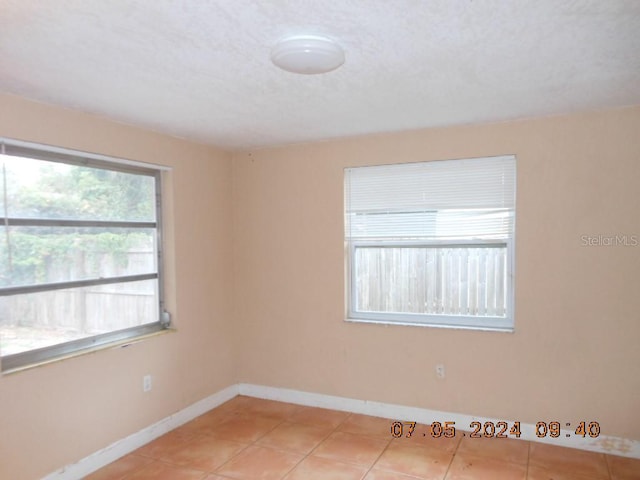 unfurnished room with baseboards and light tile patterned floors