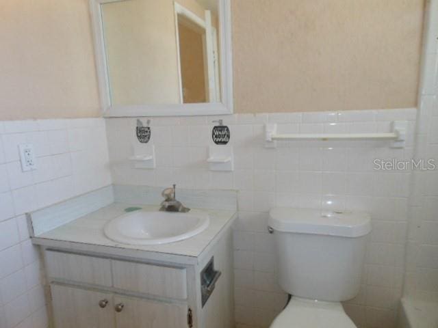 bathroom featuring wainscoting, vanity, and toilet