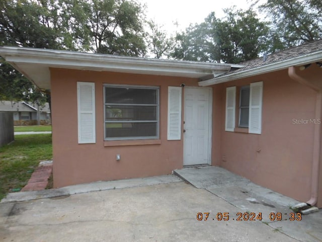 entrance to property featuring stucco siding