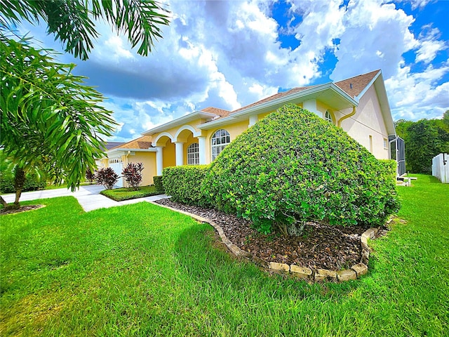 view of front of property featuring stucco siding, driveway, an attached garage, and a front yard