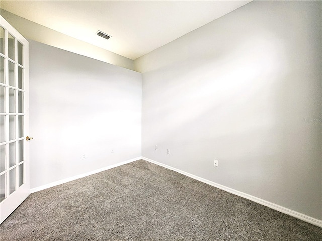 unfurnished room with visible vents, baseboards, and carpet floors