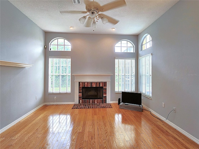 unfurnished living room with a healthy amount of sunlight, light wood-type flooring, and a fireplace