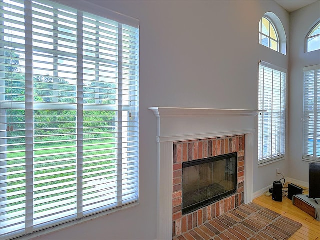 interior details featuring wood-type flooring and a brick fireplace