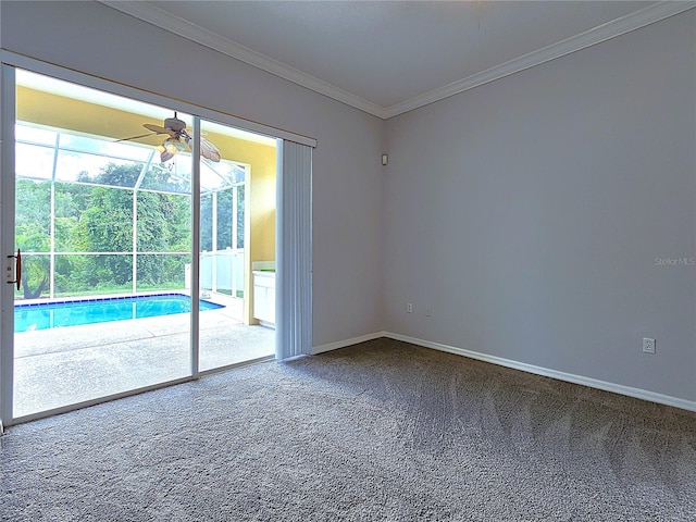 carpeted spare room with baseboards, ornamental molding, and a ceiling fan