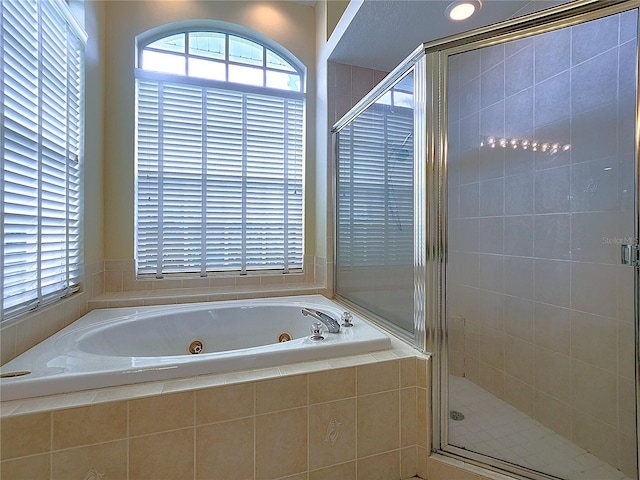 full bathroom with a jetted tub and a stall shower