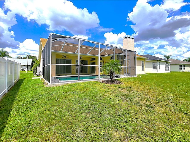 back of house with a lawn and glass enclosure