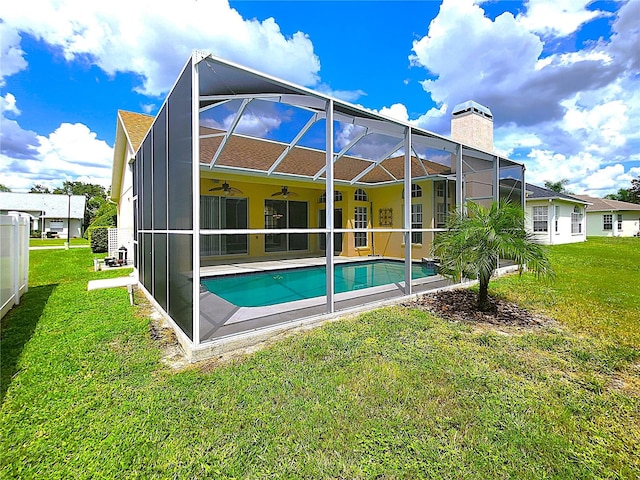 rear view of house featuring ceiling fan, a yard, an outdoor pool, a lanai, and a patio area