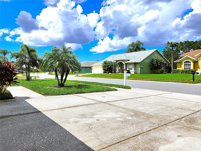 exterior space with a front lawn and curved driveway