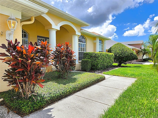 view of side of home featuring stucco siding and a yard