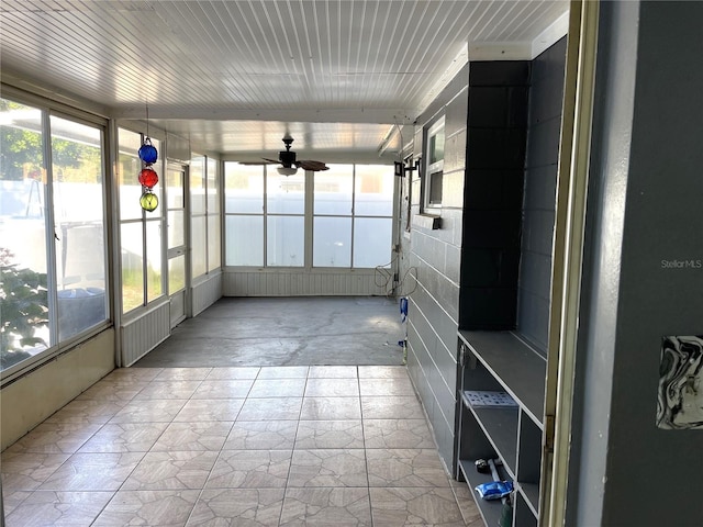 unfurnished sunroom with ceiling fan