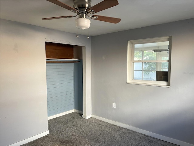 unfurnished bedroom featuring ceiling fan, a closet, and dark colored carpet