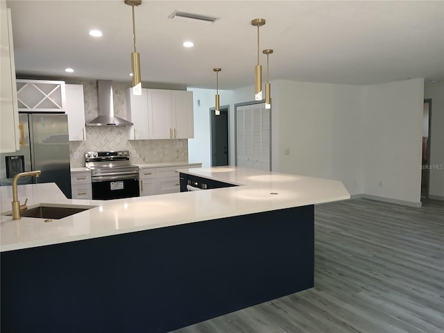 kitchen with wall chimney exhaust hood, sink, white cabinetry, pendant lighting, and stainless steel appliances