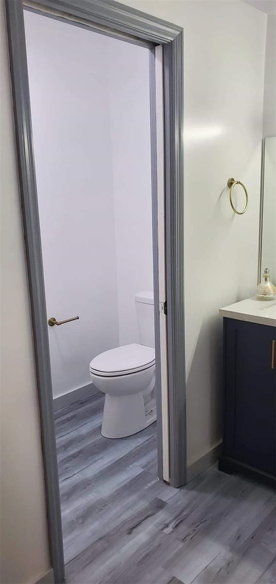 bathroom with vanity, hardwood / wood-style flooring, and toilet