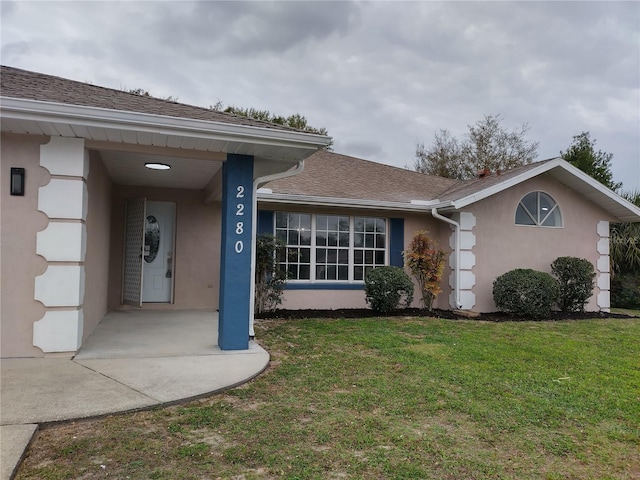 property entrance with a lawn