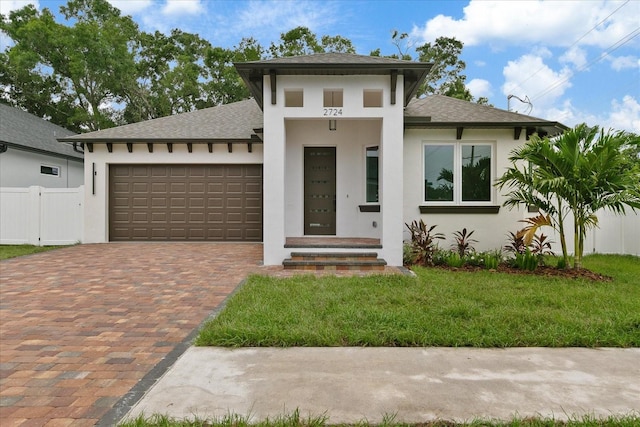 prairie-style home featuring a garage and a front yard