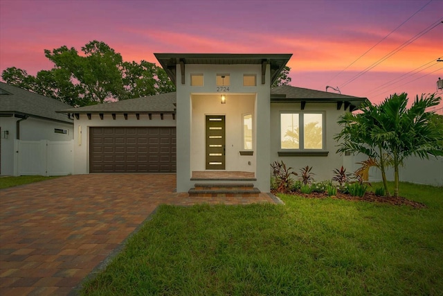 view of front of property featuring a garage and a yard