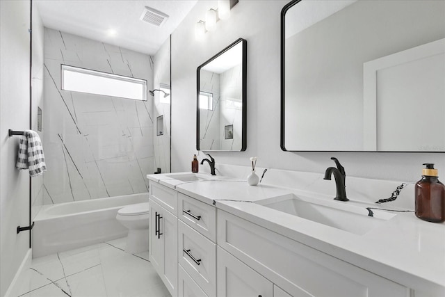 full bathroom featuring tiled shower / bath, vanity, and toilet