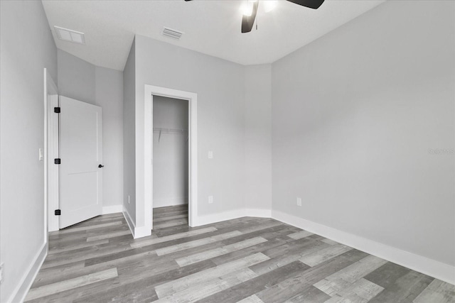 unfurnished bedroom featuring ceiling fan, light hardwood / wood-style floors, and a closet