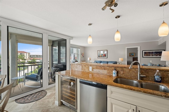 kitchen with hanging light fixtures, beverage cooler, stainless steel dishwasher, and sink