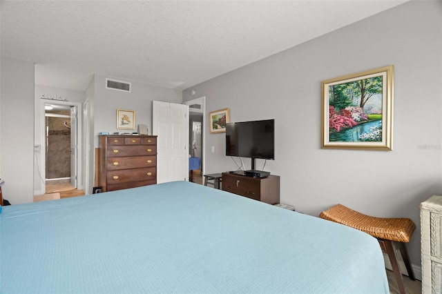 bedroom with a textured ceiling and connected bathroom