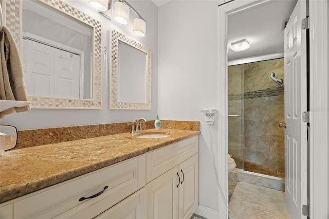 bathroom featuring toilet, vanity, and walk in shower