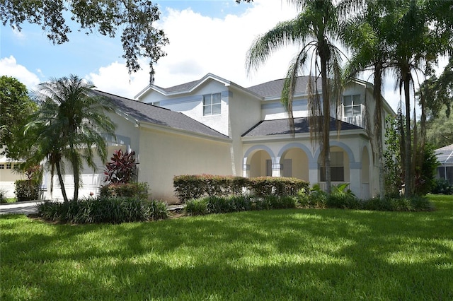 view of front of property with stucco siding, driveway, a garage, and a front lawn