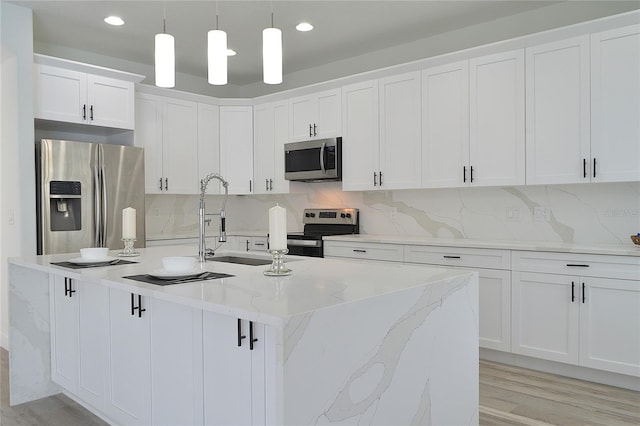 kitchen with light wood-type flooring, white cabinets, backsplash, and stainless steel appliances