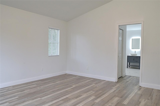 empty room with sink and light hardwood / wood-style flooring