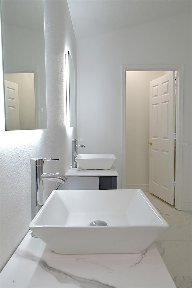 bathroom with tile patterned flooring, vaulted ceiling, and vanity