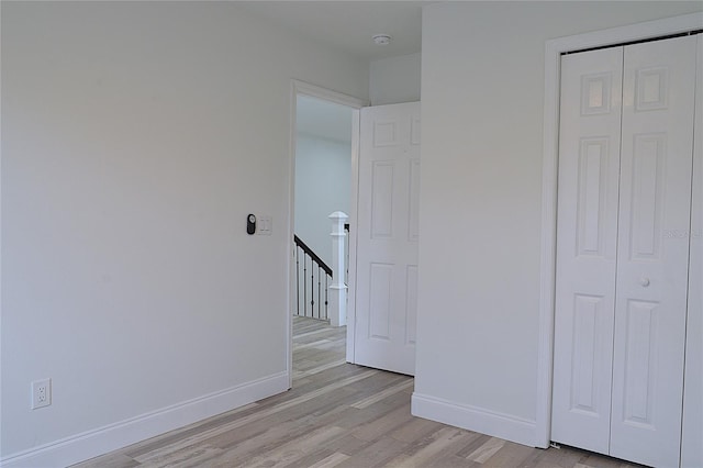 unfurnished bedroom featuring a closet and light wood-type flooring