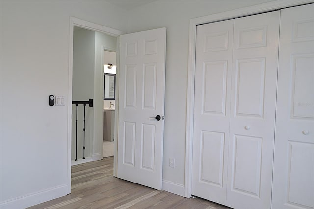 unfurnished bedroom featuring light hardwood / wood-style floors and a closet