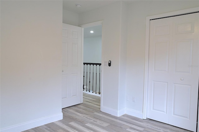 unfurnished bedroom with a closet and light hardwood / wood-style floors