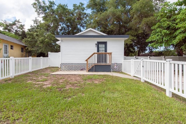 rear view of property with a yard