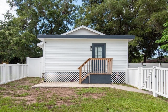 rear view of property featuring a lawn