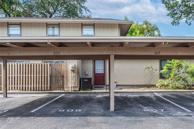 covered parking lot featuring fence