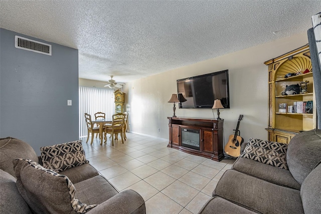 living room featuring light tile patterned floors, a textured ceiling, and ceiling fan