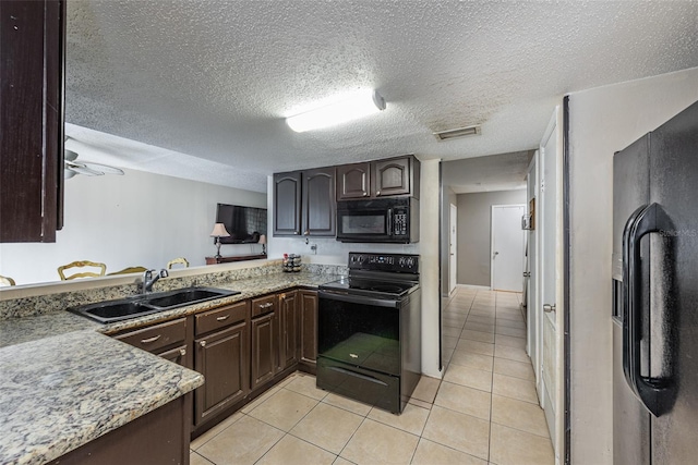 kitchen with black appliances, sink, light tile patterned floors, dark brown cabinetry, and a textured ceiling