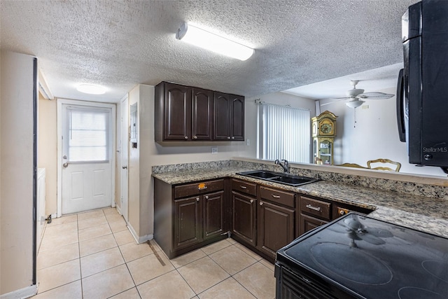 kitchen featuring sink, light tile patterned floors, dark brown cabinetry, a textured ceiling, and ceiling fan