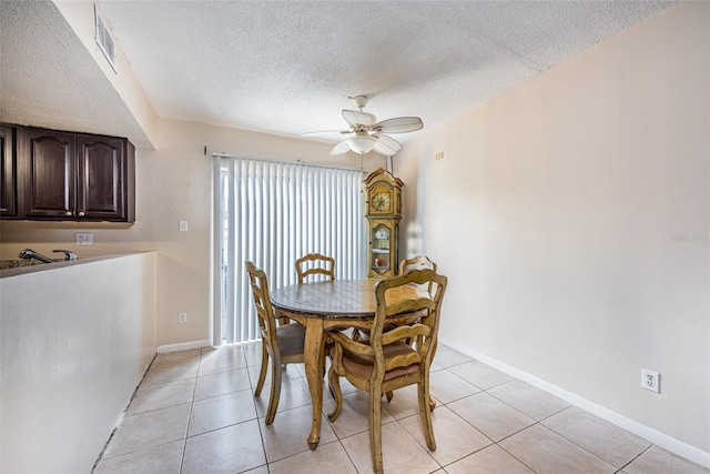 dining space with a textured ceiling, ceiling fan, and light tile patterned floors