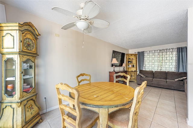 dining area with a textured ceiling, ceiling fan, and tile patterned floors