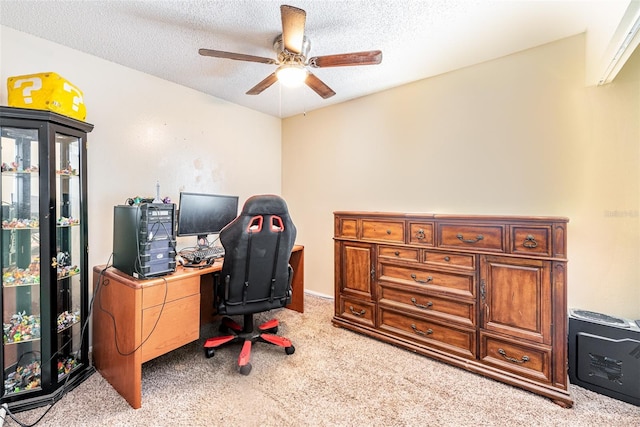 carpeted office space featuring a textured ceiling and ceiling fan