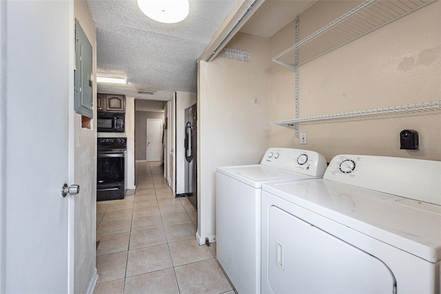 laundry room featuring a textured ceiling, independent washer and dryer, and light tile patterned floors