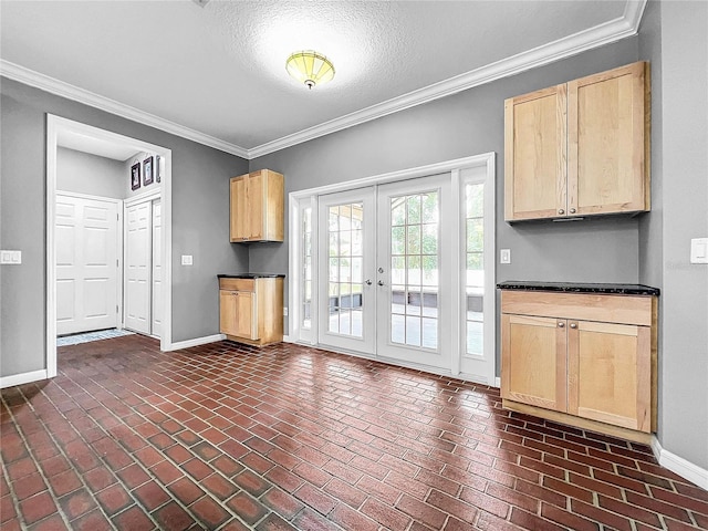 kitchen featuring french doors, ornamental molding, light brown cabinetry, and a textured ceiling