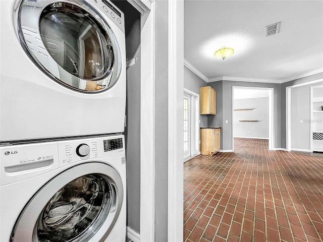 clothes washing area with crown molding, radiator heating unit, and stacked washer / dryer