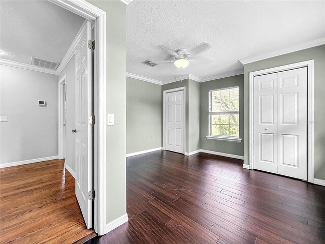 unfurnished bedroom with crown molding, ceiling fan, dark hardwood / wood-style flooring, and a textured ceiling