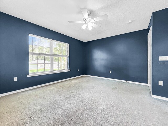 carpeted empty room with a textured ceiling and ceiling fan