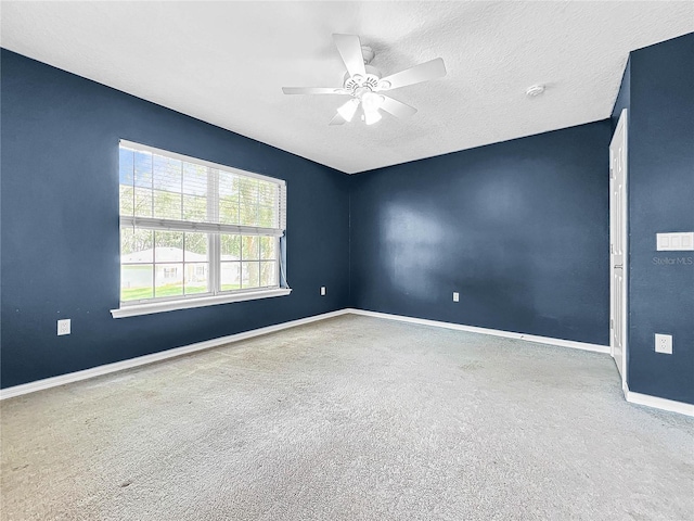 carpeted empty room with ceiling fan and a textured ceiling